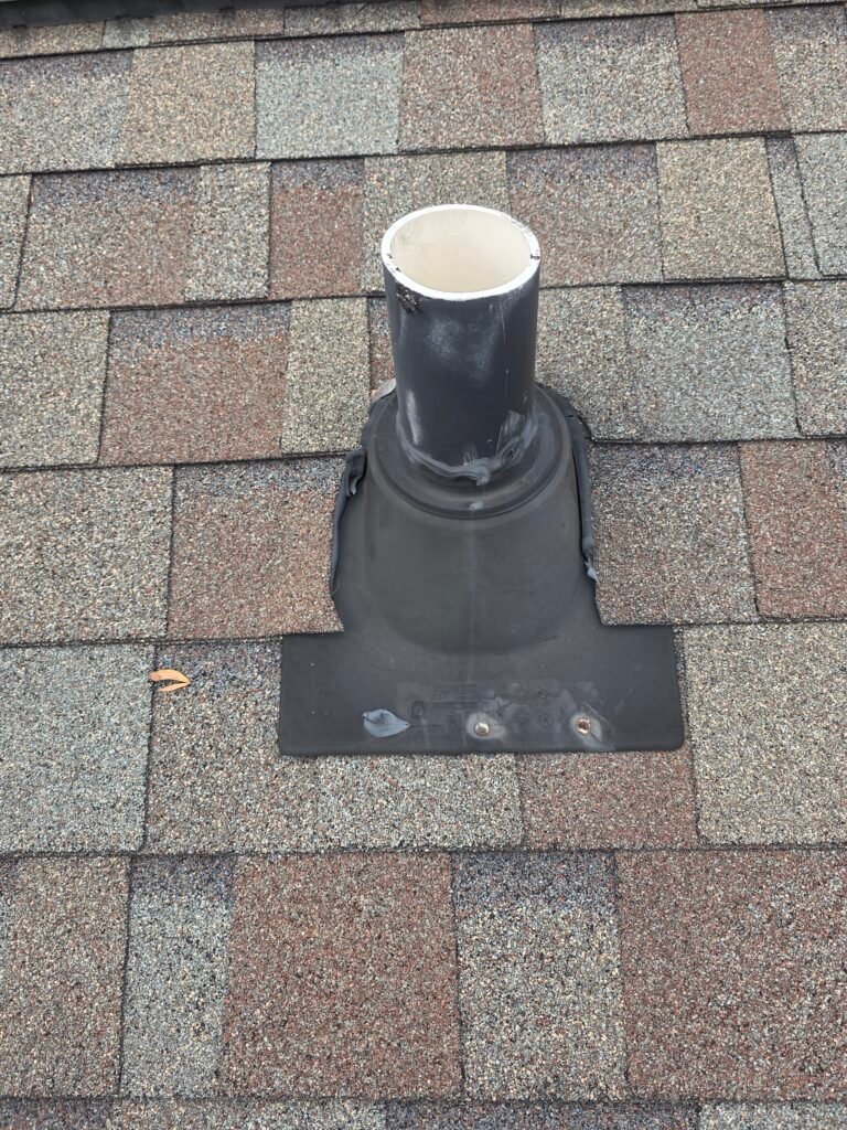 Vent-pipe flashing and rubber boot surrounded by asphalt shingles in a HopeStar Roofing project photo.