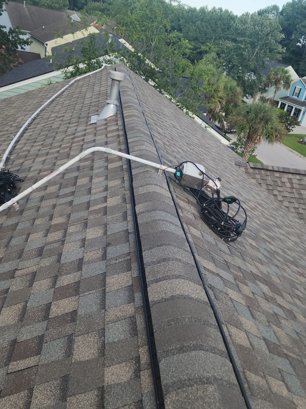 Completed shingle roof with solar wiring staged for panel reinstallation