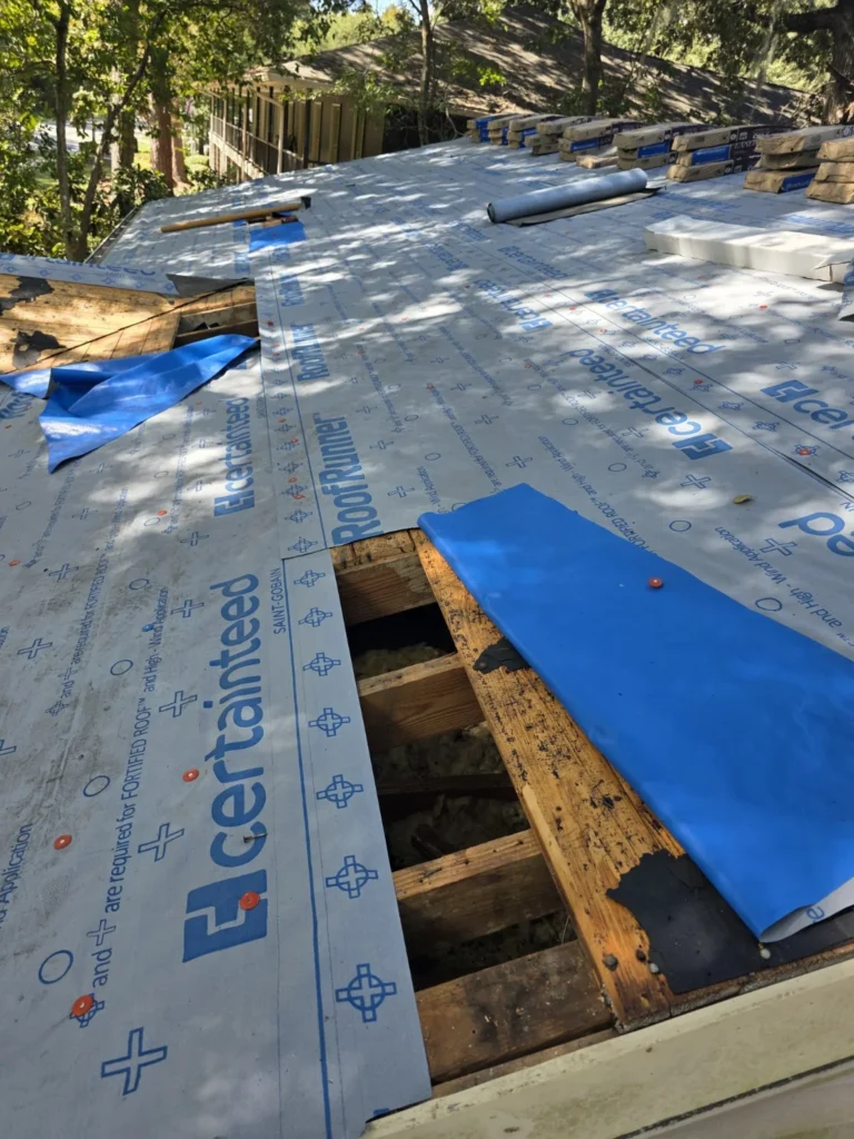 Exposed wood decking and CertainTeed RoofRunner underlayment during a Charleston roof replacement